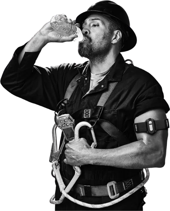 Worker in a harness drinking from a water bottle while wearing an Epicore armband