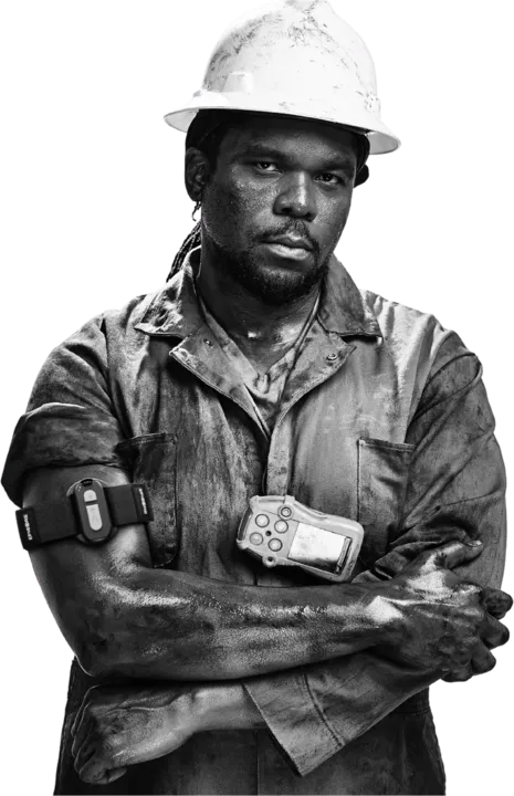 Worker in a white hard hat with a gas detector clipped to their shirt, wearing an Epicore armband